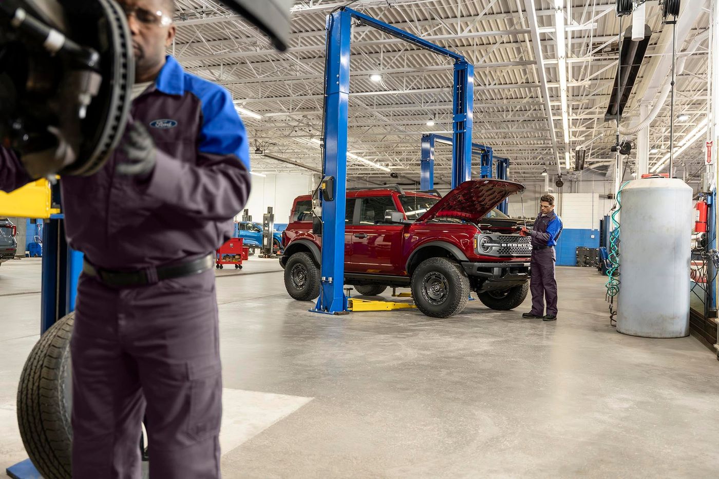 Ford technician checking the oil on a Ford Bronco SUV in the service bay