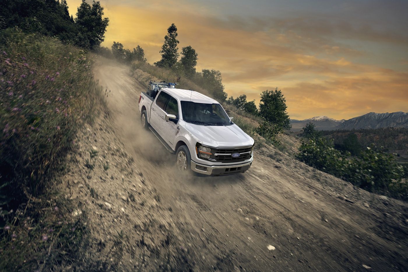 Ford F-150 STX FX4 in Oxford White driving down a dirt road with an ATV in the bed