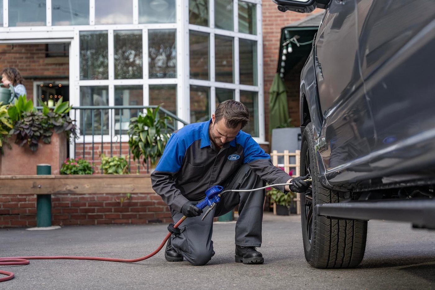 Ford technician filling air into a tire, a summer heat check for Ford owners in Gordon, TX