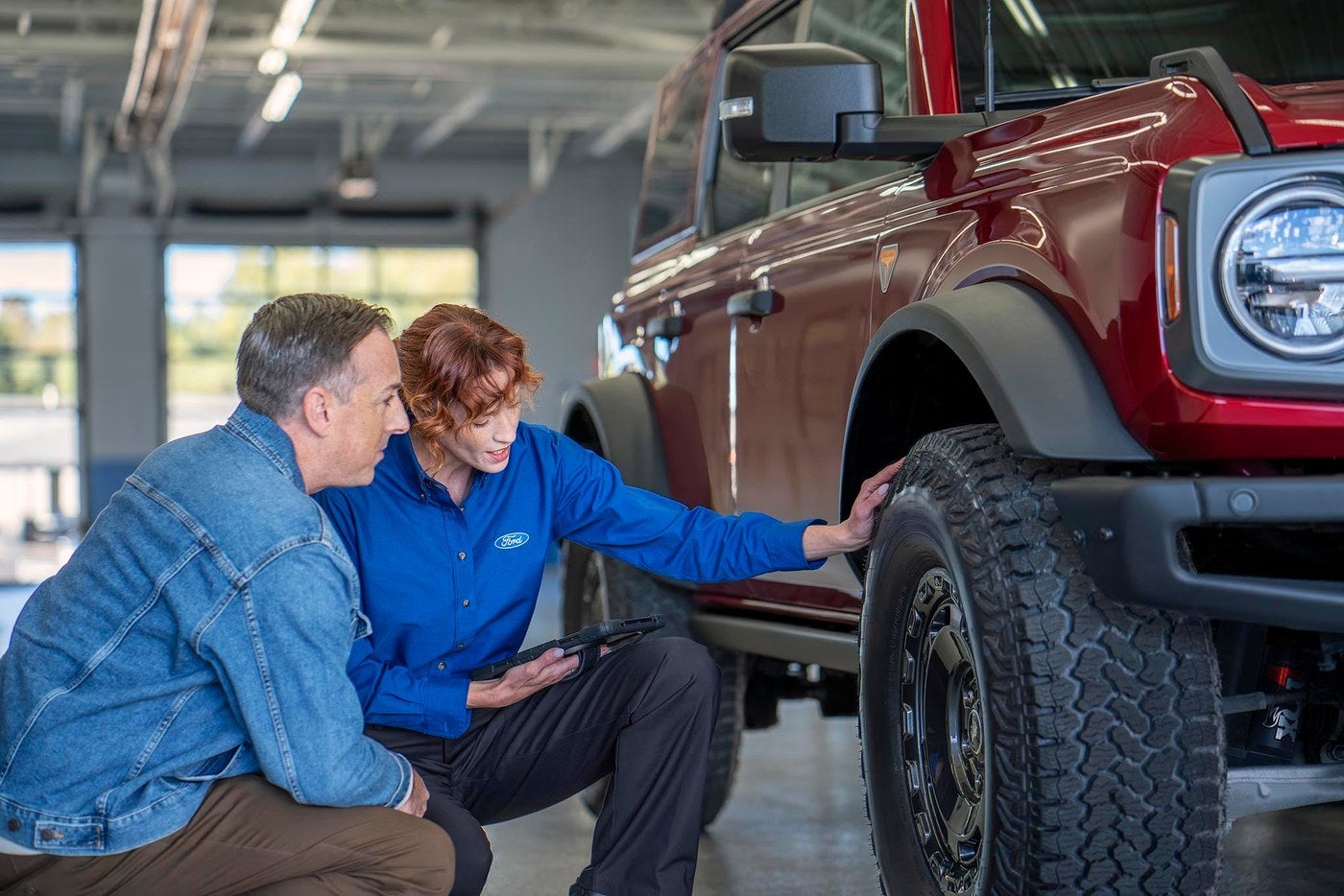 Ford service advisor and owner checking the wear on a tire