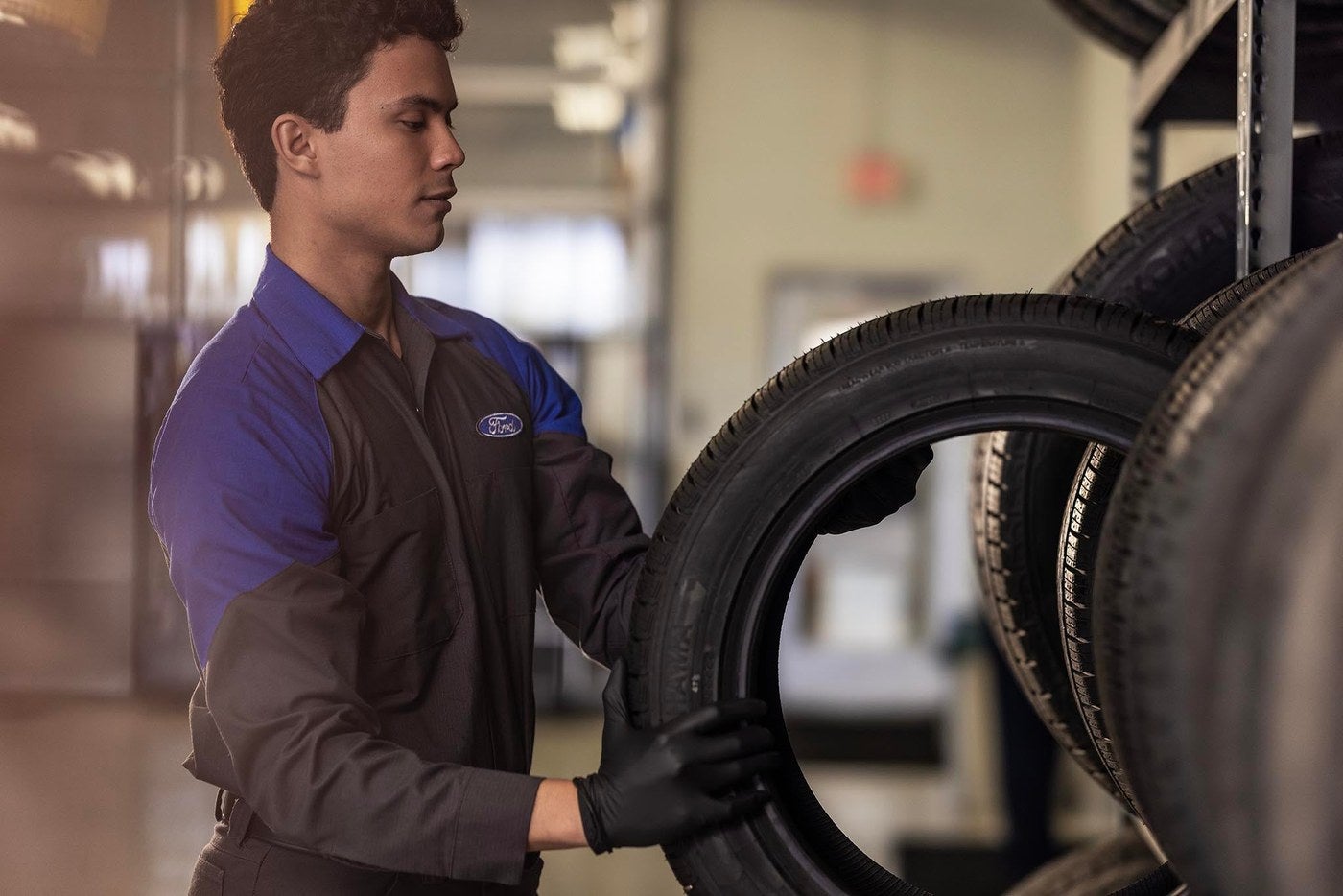 Ford service technician holding a new tire