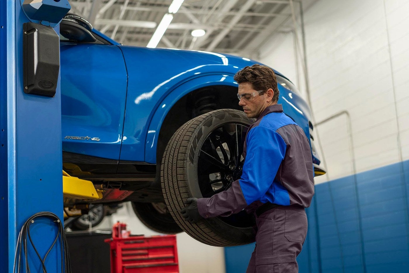 Ford technician removing a wheel from a Ford vehicle during a repair