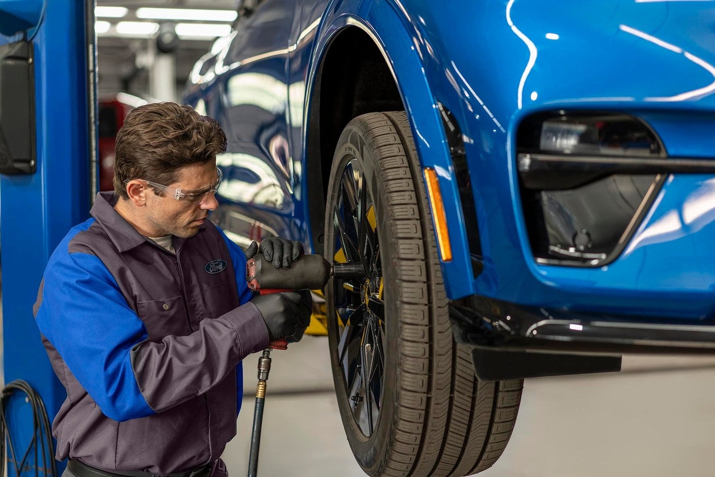 Ford service technician tightening a wheel during a fall service check